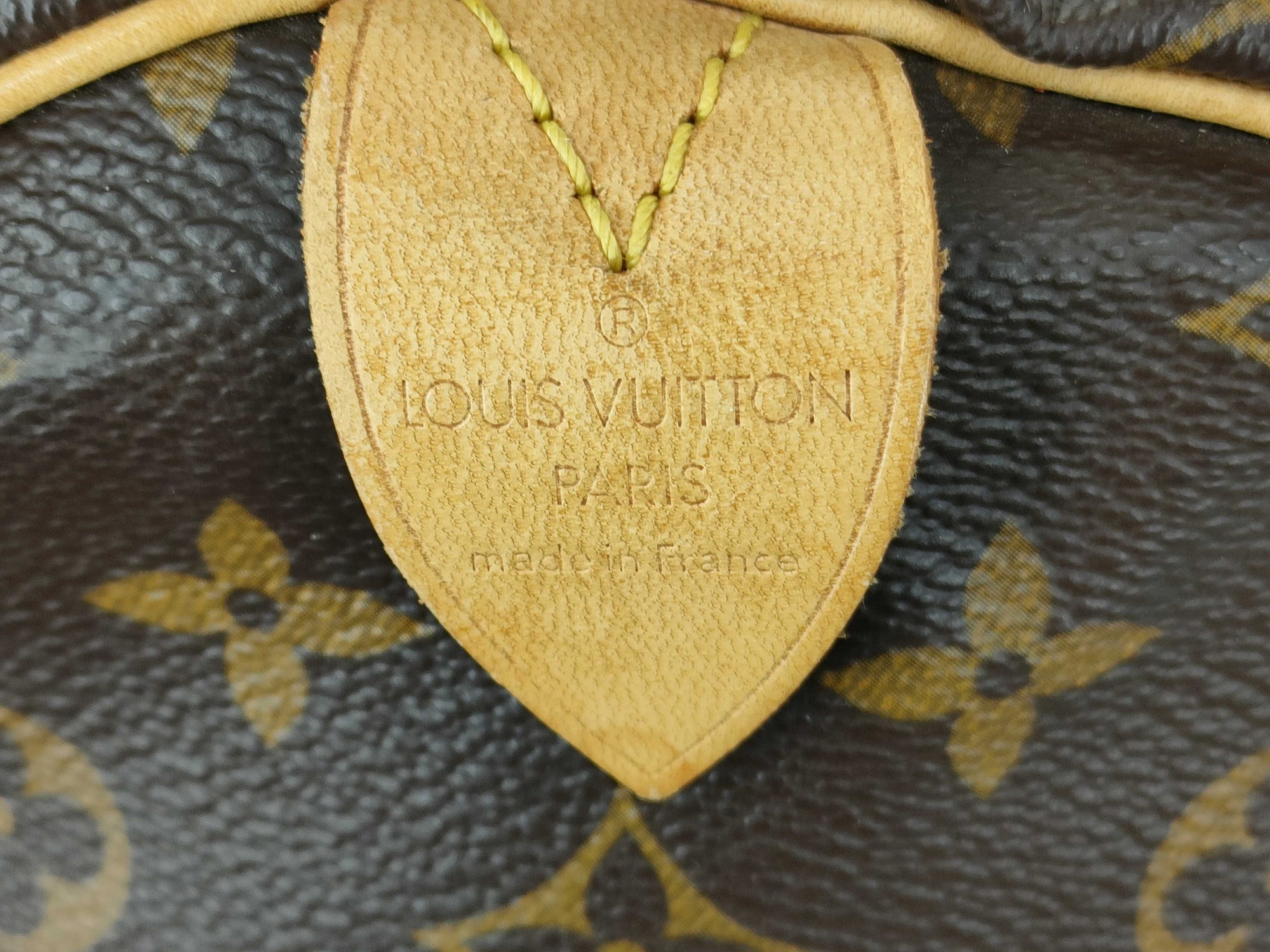 Close-up of the Louis Vuitton Paris Made in France heat stamp on a Monogram Keepall 55 Bandouliere travel duffle.