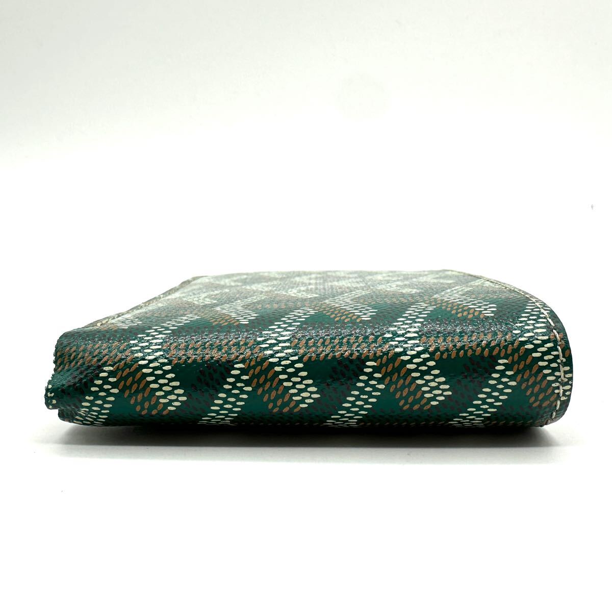 Goyard Saint Florentin green Goyardine canvas bi-fold wallet side view showing chevron pattern on white background.