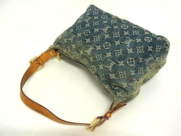 Louis Vuitton Monogram Denim Baggy PM shoulder bag in blue washed denim with tan leather strap on white background.