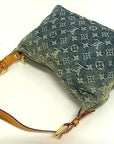 Louis Vuitton Monogram Denim Baggy PM shoulder bag in blue washed denim with tan leather strap on white background.